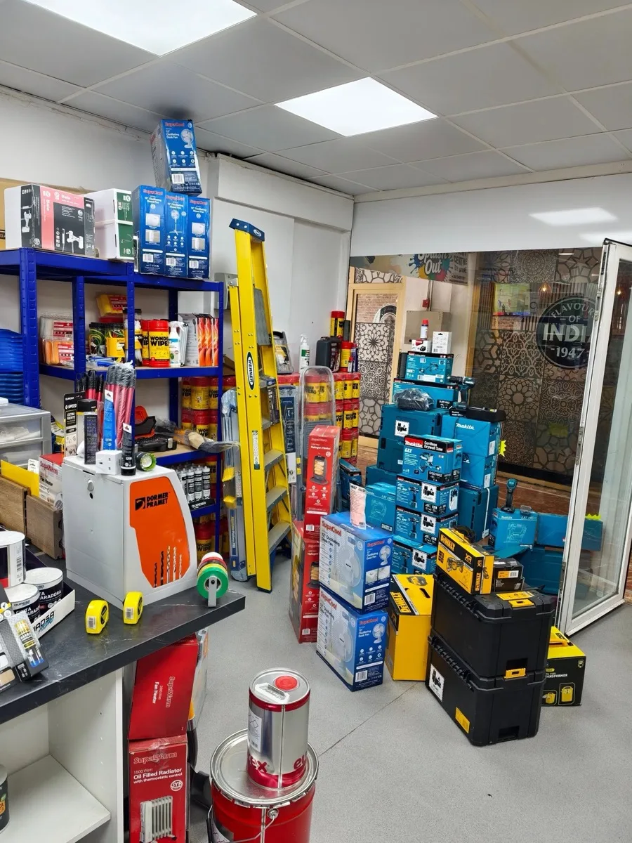 The stockroom: a yellow Werner ladder, stacks of blue Makita boxes and black DeWalt cases against blue racking.